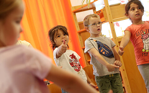 Vier Kinder aus den evangelisch lutherischen Kindergarten in Tirschenreuth, welche Dehnübungen im stehen ausführen.