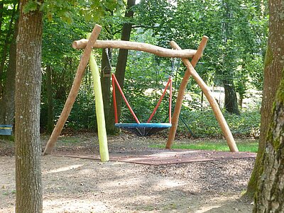 Nestschaukel aus Holz im Außenbereich der Kita Loderhof