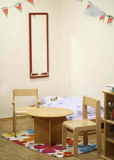 Ein kleiner runder Tisch mit zwei Stühlen im Kinderhaus Kunterbunt in Grafenwöhr.