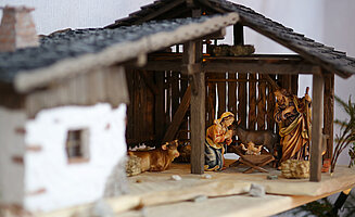 Bild: kleine geschnitzte Figuren aus Holz, in einer kleinen Scheune