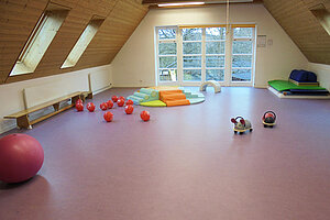 Bewegungsraum mit Spielgeräten Bewegungsraum mit Bällen, Matten und Spielgeräten unter dem Dach des Kinderhauses Etzelwang