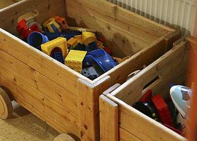 Zwei Holzkisten aus dem St. Markus Kindergarten in Weiden, in denen sich viel Kinderspielzeug befindet.