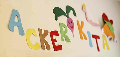 Ein Schriftzug "Acker Kita" aus Bunten Papierbuchstaben in dem St. Markus Kindergarten in Weiden