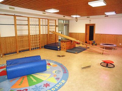 Bewegungsraum mit Turngeräten und Kletterwand in der Kita Loderhof