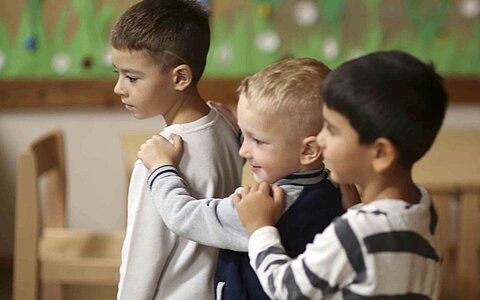 Drei kleine Jungen aus dem Kinderhaus Kunterbunt in Grafenwöhr, welche sich in einer Polonaise aufstellen