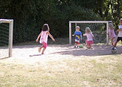 Die Kinder aus der St. Michael Kita in Weiden, die im Garten Fußball spielen.