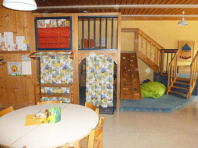 Gruppenraum mit Spielebene, Kletterwand und gemütlicher Sitzecke in der Kita Loderhof