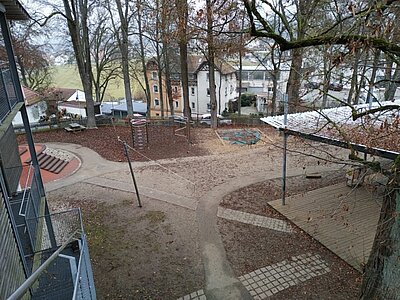 Außenansicht des weitläufigen Gartens mit Spielgeräten und Kletterbereich der Kita An der Allee