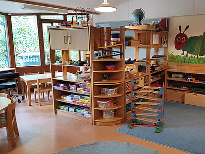 Gruppenraum mit Spielregalen, Tischen und Murmelbahn in der Erlöserkita Amberg