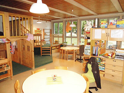 Gruppenraum mit Spielebene und Holzmöbeln in der Kita Loderhof