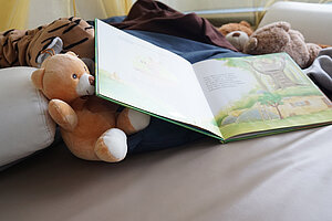 Kuscheltiere und Kinderbuch in der Leseecke