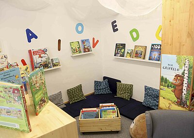 Eine Ecke in dem evangelischen Kindergarten Regenbogen mit vielen Kissen und außen herum viele Bücher in Regalen 