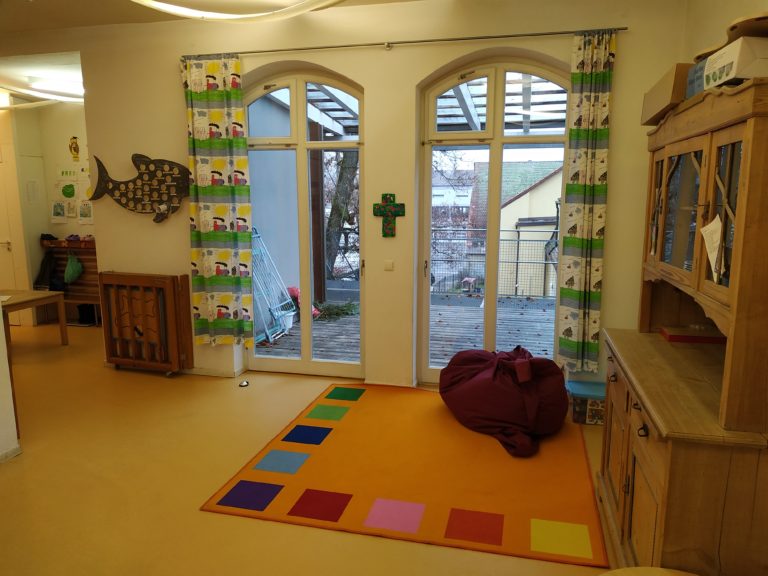 Gruppenraum mit buntem Teppich und Sitzsack in der Kita An der Allee