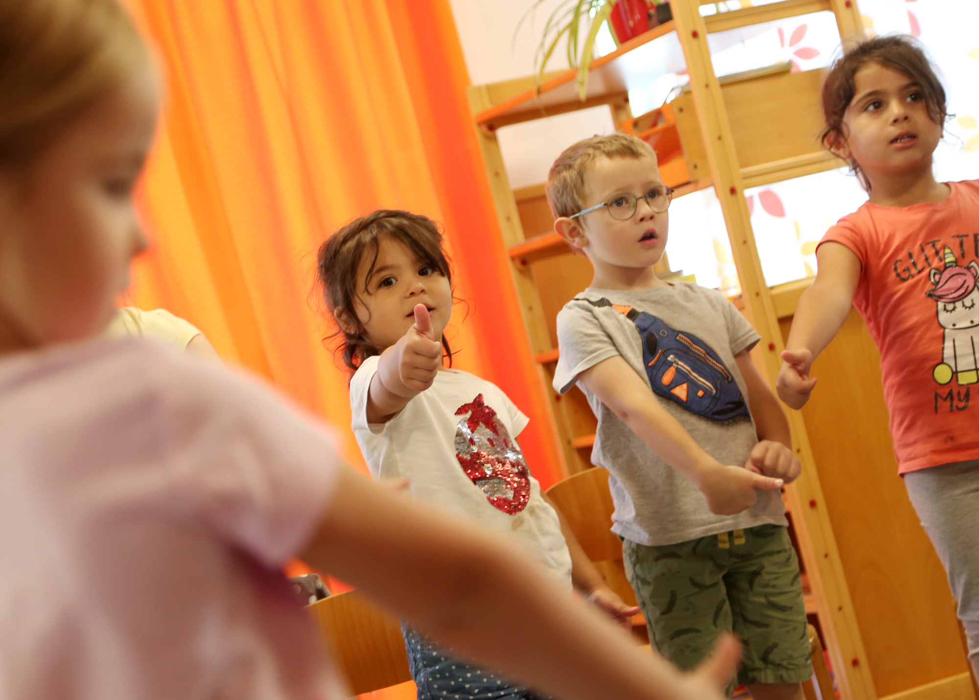 Vier Kinder aus den evangelisch lutherischen Kindergarten in Tirschenreuth, welche Dehnübungen im stehen ausführen.