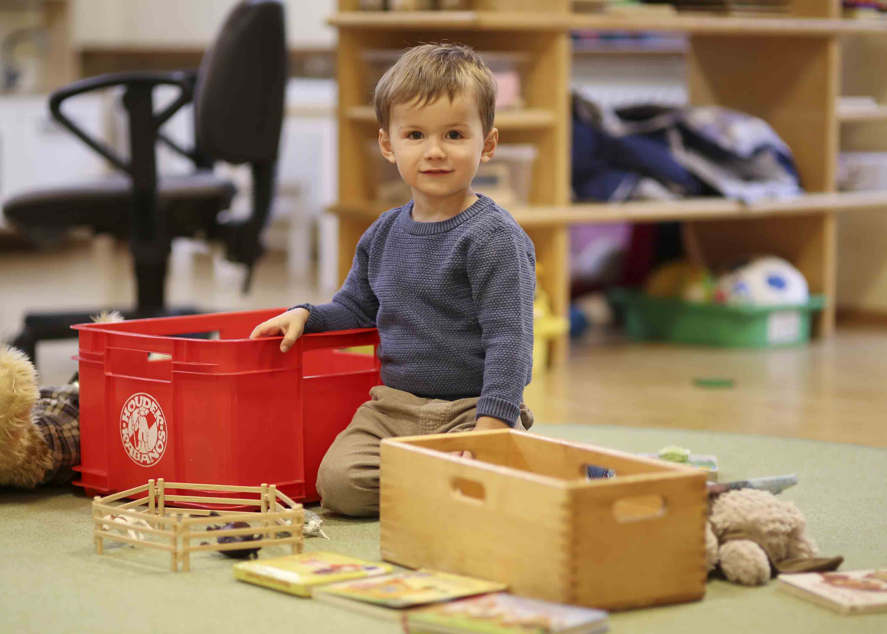 Ein kleiner Junge aus dem Kinderhaus Kunterbunt in Grafenwöhr, welcher mit Holzspielzeug spielt